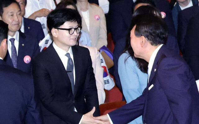 윤석열 대통령이 15일 서울 종로구 세종문화회관에서 열린 제79주년 광복절 경축식에서 퇴장하며 국민의힘 한동훈 대표와 악수하고 있다. 대통령실 제공