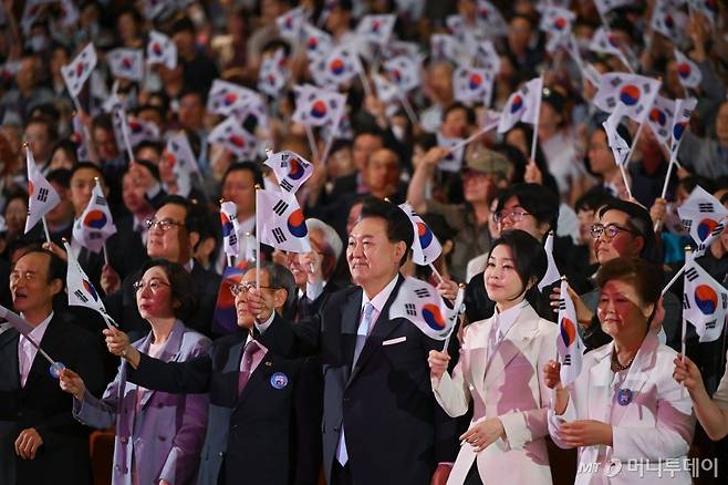 [서울=뉴시스] 조수정 기자 = 윤석열 대통령과 부인 김건희 여사가 15일 서울 종로구 세종문화회관에서 열린 제79주년 광복절 경축식에서 광복절의 노래에 맞춰 태극기를 흔들고 있다. (사진=대통령실 제공) 2024.08.15. photo@newsis.com *재판매 및 DB 금지 /사진=조수정