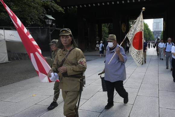 욱일기 들고 야스쿠니신사 입장하는 사람들 - 한국의 광복절이자 일본의 패전일인 15일 일본 도쿄에서 구식 군복을 입은 사람들이 욱일기를 들고 태평양전쟁 A급 전범이 합사된 야스쿠니신사에 참배하기 위해 본당으로 걸어가고 있다.  도쿄 AP 뉴시스