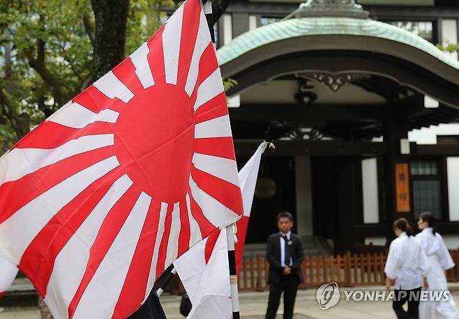 일본 패전일 야스쿠니신사 욱일기 (도쿄=연합뉴스) 박상현 특파원 = 일본 패전일인 15일 태평양전쟁 A급 전범이 합사된 도쿄 지요다구 야스쿠니신사를 찾은 이들이 욱일기를 들고 있다. 2024.8.15