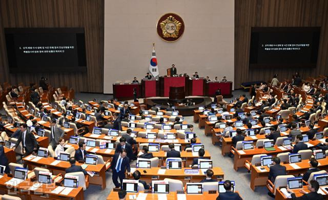 우원식 국회의장이 지난달 25일 국회에서 열린 본회의에서 순직 해병 수사 방해 및 사건 은폐 등의 진상규명을 위한 특별검사의 임명 등에 관한 법률안 재의의 건을 상정하자 의원들이 투표를 위해 이동하고 있다. 정다빈 기자