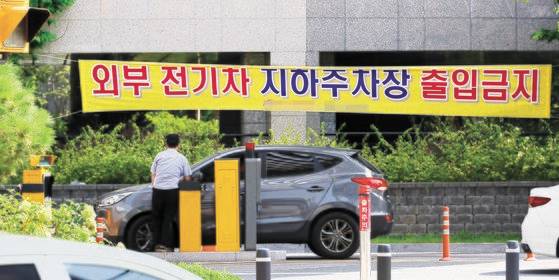 지난 12일 서울 시내 한 아파트에 외부 전기차 지하주차장 출입금지 현수막이 걸려있다.   서울시는 최근 아파트 등에서 전기차 화재가 잇따르자 완충차량 지하주차장 출입금지 등의 대책을 추진하고 있다. [연합뉴스]