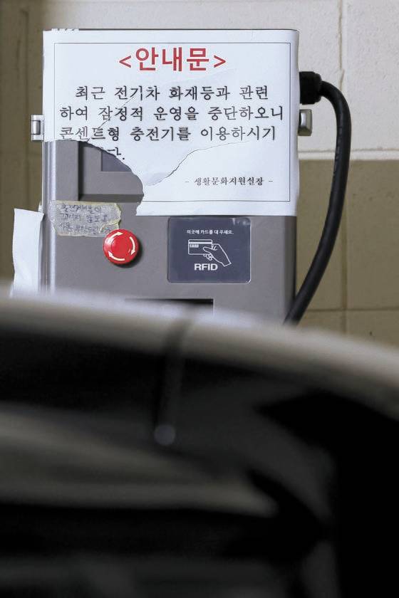 지난 12일 서울 시내 한 아파트 지하 주차장에 설치된 고정형 전기차 충전기에 운영 중단 안내문이 붙어 있다. [연합뉴스]