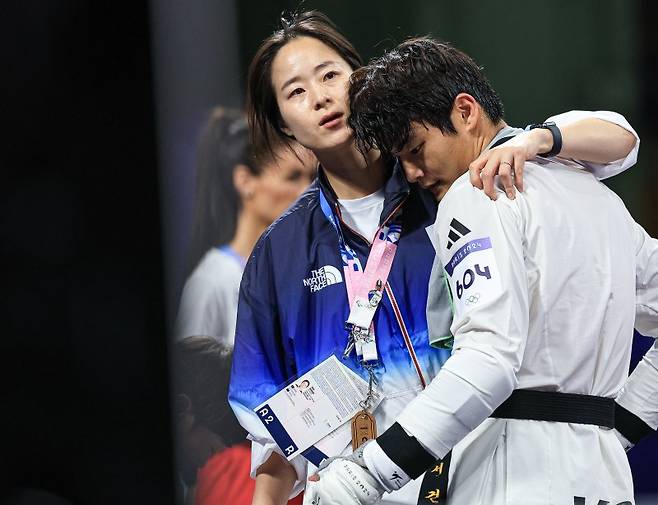 대한민국 태권도 국가대표팀 서건우 선수가 10일 오전(한국시간) 프랑스 파리 그랑 팔레에서 진행된 2024 파리올림픽 태권도 남자 80kg급 동메달 결정전 덴마크의 에디 흐르닉 선수와의 경기를 패배한 후 오혜리 코치의 위로를 받고 있다. / 사진=뉴스1