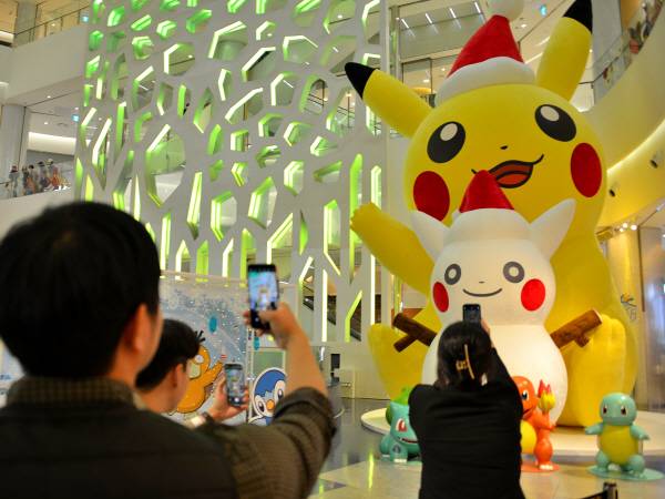 지난해 11월 롯데백화점 부산 광복점에서 열린 포켓몬 팝업스토어에서 고객들이 대형 피카츄 인형을 배경으로 기념 촬영을 하고 있다. 롯데백화점 제공
