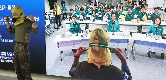 임태희 경기도교육감이 19일 수원 남부청사 전시종합상황실에서 열린 ‘2024 을지연습 최초 상황 보고’에 참석해 방독면 착용법 설명을 듣고 있다.