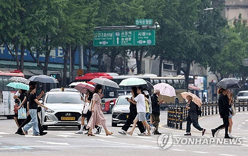 비가 내린 지난 5일 서울 중구 한국은행 앞 사거리에서 시민들이 우산을 쓴 채 걸어가고 있다. [연합뉴스]