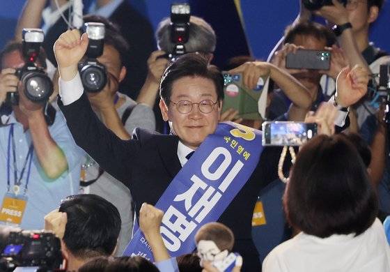 연임에 성공한 이재명 더불어민주당 대표가 18일 오후 서울 송파구 올림픽체조경기장에서 열린 전당대회에서 당선이 확정 된 뒤 두 손을 들어 당원들에게 인사하고 있다. 전민규 기자