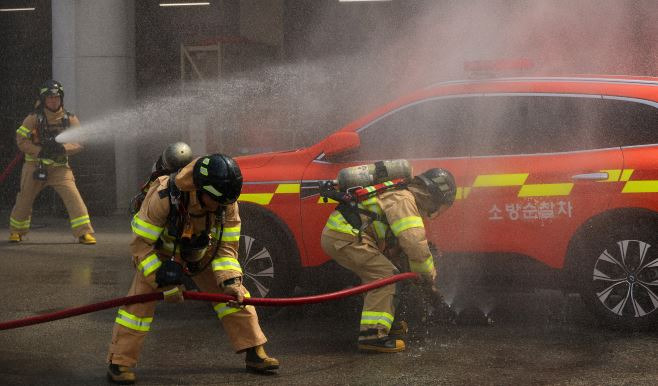 Firefighters demonstrate the extinguishing of EV fires at the Busan Fire and Disaster Headquarters on August 14. Yonhap News