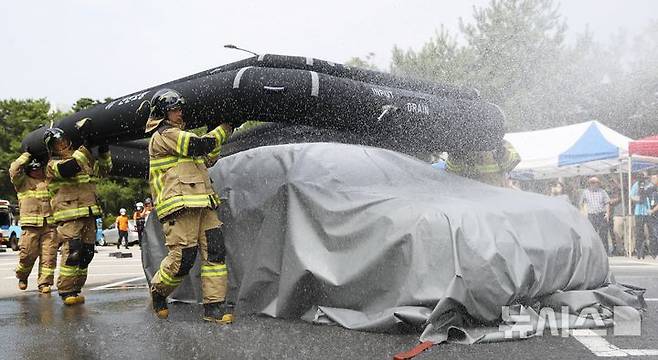 [인천=뉴시스] 김동영 기자 = 13일 오전 인천 연수구 송도2동 행정복지센터 옆 주차장에서 열린 ‘전기자동차 화재 대응 민·관 합동 교육’에서 소방대원들이 전기차 수조를 전개하고 있다. 이날 교육은 연수구청과 송도소방서 주최로 열렸으며, 지역 주민과 공무원 등 200여 명이 참여했다. 2024.08.13. dy0121@newsis.com