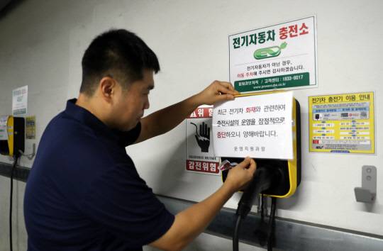 세종시교육청 관계자가 청사 지하주차장 전기차 충전시설 운영을 중단한다는 내용의 안내문을 부착하고 있다. 연합뉴스.