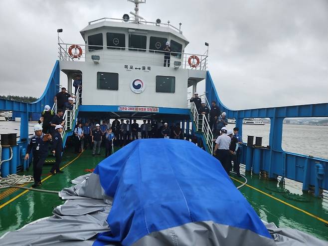 ▲ 한국해양교통안전공단(KOMSA)이 지난 11일(화) 전남 목포여객선터미널에 정박한 차도선에서 해양수산부 등 관계기관과 함께 국내 최초로 선상 전기차 화재대응 민관합동 훈련을 시행하는 모습 [한국해양교통안전공단(KOMSA)]