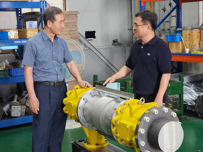 오두만 극동산업 대표(왼쪽)가 양병엽 삼성전자 스마트공장실행팀 위원과 공장 내에 놓인 선박용 엔진 부품을 살펴보고 있다.  박승주 기자