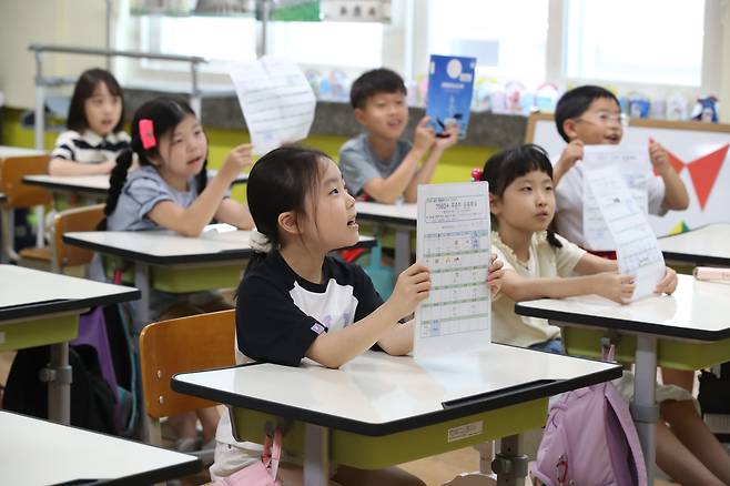 19일 오전 대구 달서구 대구덕인초등학교 2학년 교실에서 여름방학을 마치고 등교한 학생들이 방학 동안 한 숙제를 들어 보이고 있다. /연합뉴스