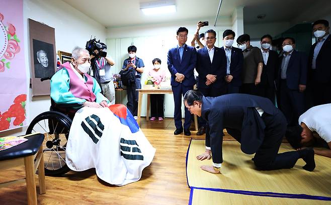 한덕수 국무총리가 21일 수원시 장안구 보훈공단 보훈원을 방문해 오성규 애국지사 등 보훈원 입소자들을 위문하며 청년 인턴들과 101번째 생신을 맞은 오성규 지사에게 큰절하고 있다 / 사진 = 연합뉴스