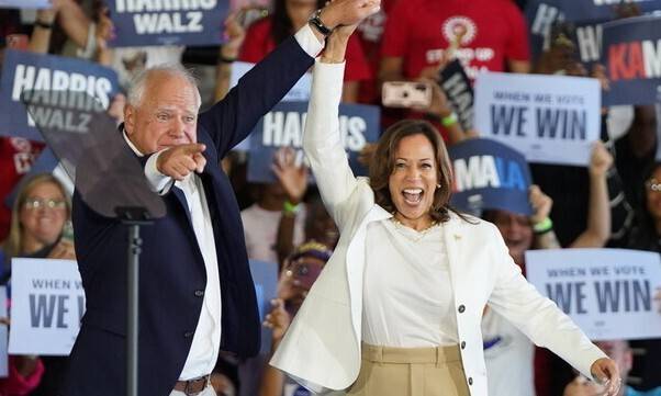 미국 민주당의 대선 후보로 사실상 결정된 카멀라 해리스 부통령과 팀 월즈 미네소타 주지사가 7일 미시간주 디트로이트 메트로 공항에서 열린 유세에서 손을 맞잡고 지지자들의 환호에 답하고 있다. 디트로이트/EPA 연합뉴스