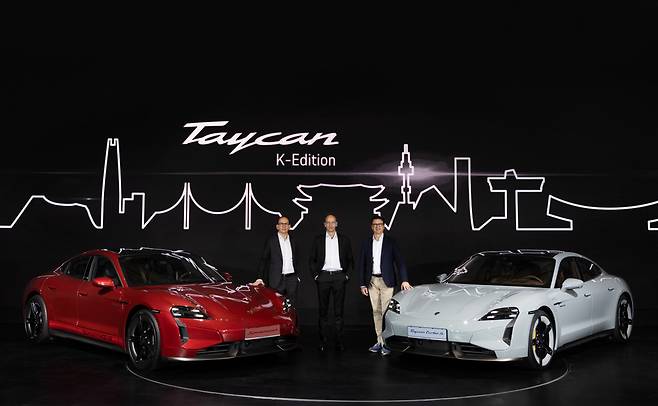 From left: Alexander Fabig, vice president of individualization & classics at Porsche, Holger Gerrmann, CEO of Porsche Korea, and Kevin Giek, vice president of product line limousines at Porsche pose for photos with the new Korean-themed Taycan (left) and new Taycan at the Grand Hyatt Seoul on Thursday. (Porsche Korea)