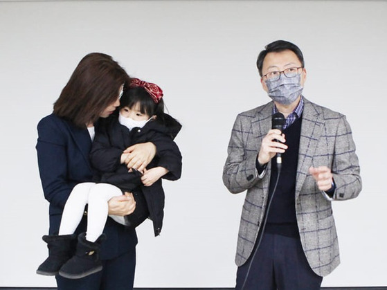 David Jea (right) stands next to his adopted daughter, who is carried by Rep. Kim Mi-ae. [KIM MI-AE]