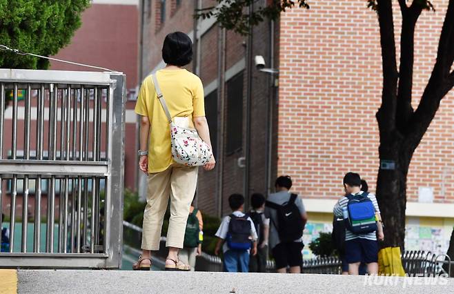 '우리 아이 괜찮을까'서울 송파구 오금동의 한 초등학교 등교시간, 자녀를 교문 안으로 들여보낸 학 학부형이 걱정스러운 듯 자녀의 뒷 모습을 지켜보고 있다.