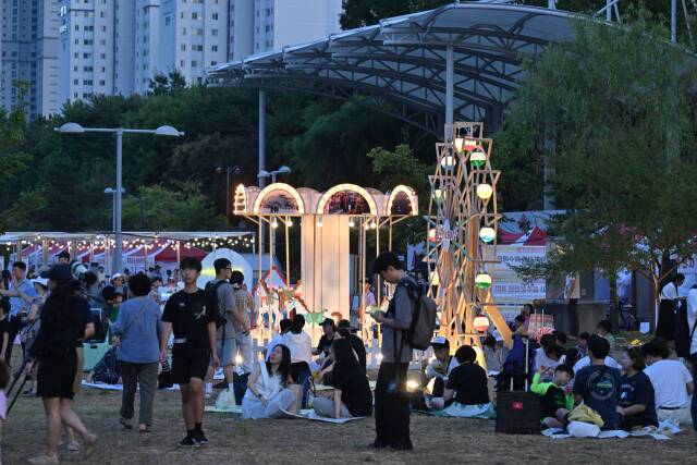 지난 10일 인천 연수구 송도 달빛공원에서 열린 ‘제5회 新송도해변축제’에 시민들이 모형으로 재현한 송도유원지 회전목마, 관람차를 보고 있다. 조병석기자
