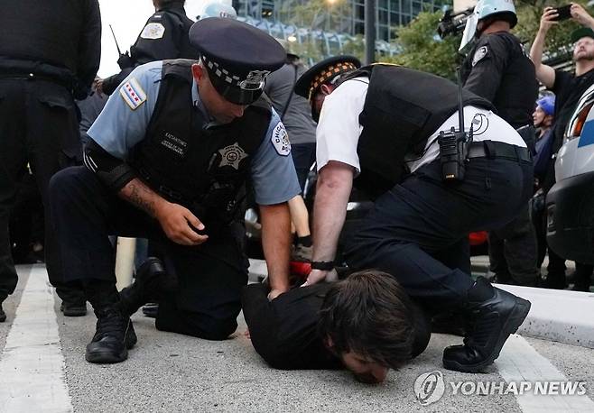 미 경찰에 체포되는 친팔레스타인 시위대 (시카고 로이터=연합뉴스) 20일(현지시간) 미국 민주당 전당대회가 열린 일리노이주 시카고의 이스라엘 영사관 인근에서 현지 경찰이 친팔레스타인 시위대를 체포하고 있다. 이날 시위대는 이스라엘에 대한 미국 정부의 무기 지원 중단을 요구하며 경찰과 충돌했다. 2024.08.21 passion@yna.co.kr