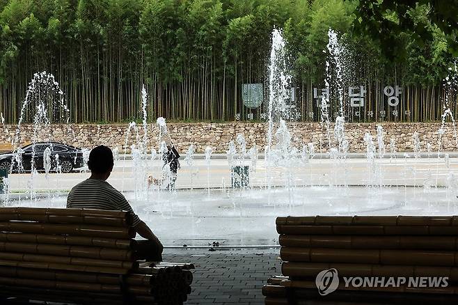 시원한 물줄기 보며 휴식 (담양=연합뉴스) 김혜인 기자 = 폭염 경보가 발효 중인 21일 오후 전남 담양군 담양읍 관방제림에서 한 시민이 분수를 바라보며 휴식을 취하고 있다. 2024.8.21 in@yna.co.kr