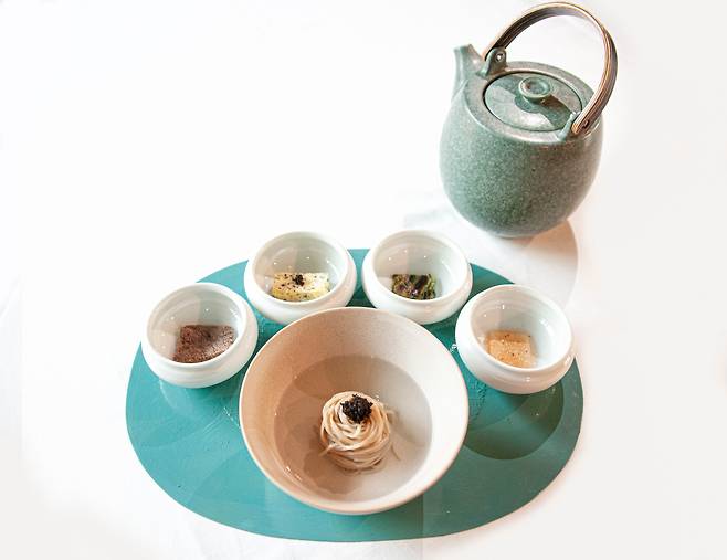 정식당의 이번 여름 신메뉴인 평양냉면. 면 위에 고명으로는 호주 태즈메이니산 트러플이 뿌려져 있다. 왼쪽부터는 양지 수육과 더덕 김치, 계란말이, 방아 부추전, 물김치 등이 놓여져 있다. /정식당