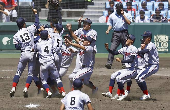 한국계 민족학교 교토국제고등학교가 23일 일본 효고현 니시노미야시의 고시엔 구장에서 열린 제 106회 일본 전국고교야구선수권대회 결승에서 연장 10회 접전 끝에 간토다이이치고를 2-1로 제압하고 정상에 올라섰다. 우승을 확정한 선수들이 기쁨을 나누고 있다. 교도통신 연합뉴스