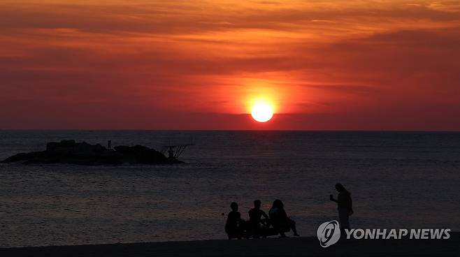 폭염 예고…붉게 솟는 태양 (강릉=연합뉴스) 유형재 기자 = 23일 강원 강릉시 경포해수욕장 백사장에 열대야를 피해 나온 시민들이 붉은 솟아오르는 일출을 바라보고 있다. 기상청은 이날 강릉의 낮 최고기온이 36도까지 올라갈 것으로 예보했다. 2024.8.23 yoo21@yna.co.kr