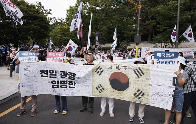 제79주년 광복절인 지난 15일 항일독립선열 선양단체 연합(항단연)이 서울 용산구 효창공원 내 삼의사 묘역에서 개최한 광복절 기념식을 마친 참석자들이 독립기념관장 임명 철회 등을 요구하며 행진을 하고 있다. 연합뉴스