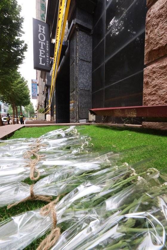 25일 오전 경기도 부천 호텔 화재사고 현장 앞에 고인을 추모하는 국화꽃이 놓여 있다. [연합뉴스]