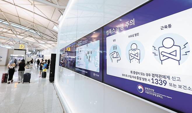 Quarantine and hygiene instructions for mpox and its symptoms are displayed on electronic screens in Incheon International Airport in July. [YONHAP]