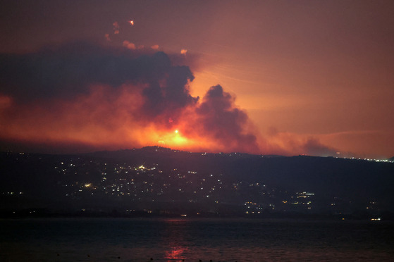 A view shows smoke and fire on the Lebanese side of the border with Israel after Israel said it had detected the armed group Hezbollah preparing to attack Israel and had carried out pre-emptive strikes on Hezbollah targets in Lebanon, as seen from Tyre, southern Lebanon, on Sunday. [REUTERS/YONHAP]