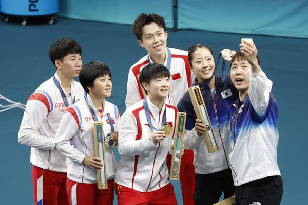 대한민국 탁구 대표팀 신유빈, 임종훈 선수가 7월 30일(한국시각) 프랑스 파리 사우스 파리 아레나4에서 열린 '2024 파리올림픽' 탁구 혼합복식 시상식에서 금메달을 획득한 중국 왕추친, 쑨잉사와 은메달을 획득한 북한 리종식, 김금용과 함께 기념촬영을 하고 있다. /뉴시스