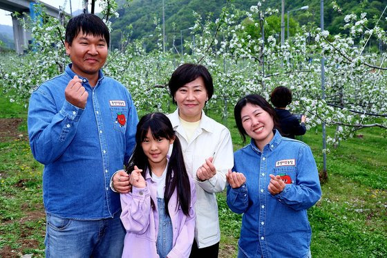 송미령 농림축산식품부 장관이 4월 21일 경북 문경 따봄농장(대표 이주연)을 방문해 사과꽃 수분 작업을 한 뒤 이주연 양 가족과 포즈를 취했다. 송 장관은 여름 휴가 때 다시 농장을 방문해 작황을 점검했다.[사진 농림부]