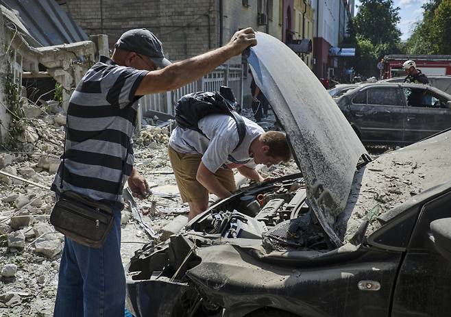 지난 6일(현지시간) 우크라이나 하르키우 시내에서 현지 주민들이 러시아의 로켓 공격에 파괴된 차량을 살펴보고 있다. 이날 러시아의 로켓 공격으로 최소 8명의 주민이 부상했다. 사진=EPA 연합뉴스&nbsp;