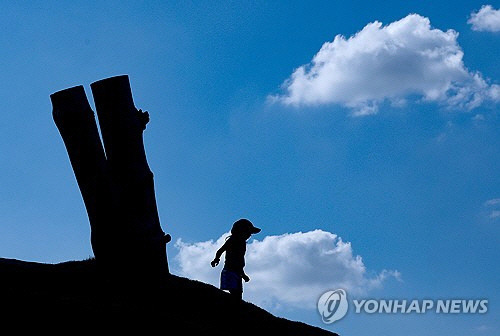 맑은 날씨를 보이는 28일 오후 서울 종로구 열린송현 녹지광장에서 한 어린이가 언덕에 올라가 있다. [연합뉴스]