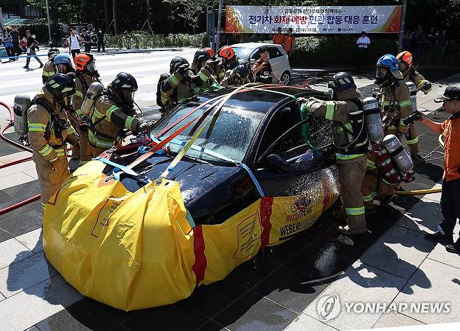 '전기차 화재는 포켓식 수조로 완진을' (서울=연합뉴스) 이지은 기자 = 28일 오전 서울 성동구 왕십리광장에서 성동소방서 소방대원들이 아파트 주차장 전기차 화재 발생 상황을 가정해 열린 대응 훈련에서 포켓식 수조 설치를 통해 진화하고 있다. 2024.8.28 jieunlee@yna.co.kr