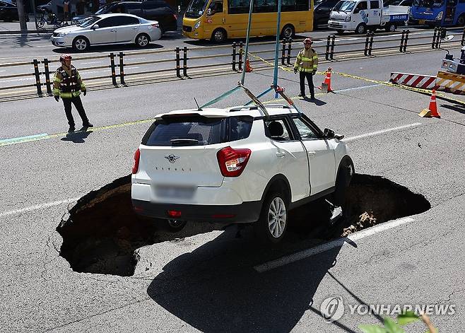 성산로에 땅꺼짐 발생, 옮겨지는 사고차량 (서울=연합뉴스) 서대연 기자 =  29일 오전 서울 서대문구 연희동 성산로에서 발생한 땅 꺼짐 사고로 빠져버린 승용차가 크레인으로 옮겨지고 있다. 2024.8.29 dwise@yna.co.kr