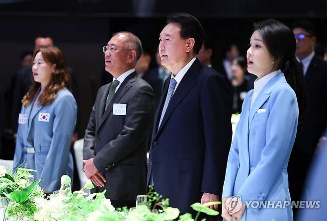 윤석열 대통령 부부, 파리올림픽 선수단 격려행사 참석    윤석열 대통령과 김건희 여사가 지난 22일 서울 한 호텔에서 열린 '2024 파리올림픽 선수단 격려 행사'에 참석해 정의선 현대차그룹 회장 등과 애국가를 부르고 있다. [대통령실통신사진기자단]