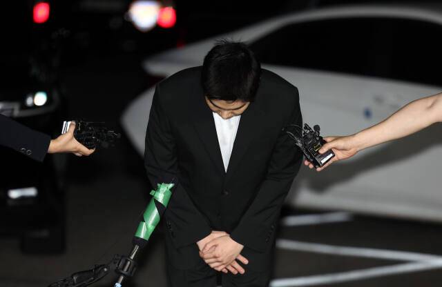 만취 상태로 전동스쿠터를 몬 혐의를 받는 그룹 방탄소년단(BTS)의 슈가(민윤기)가 지난 23일 경찰에 출석하면서 고개 숙이고 있다. 연합뉴스