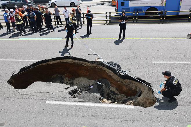 지난 29일 오전 서울 서대문구 연희동 성산로에서 발생한 땅 꺼짐(싱크홀) 현상 현장에서 경찰 및 소방 관계자들이 사고 폭 깊이를 측정하고 있다 (사진=연합뉴스)