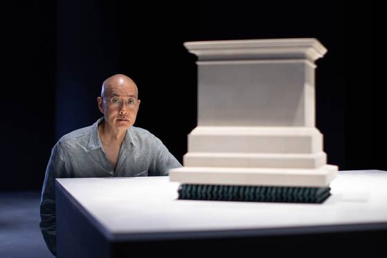 서도호 작가와 그의 움직이는 ‘공인들(1/6 스케일)’(2024). 받침대 위에 동상이 없고 대신 수많은 작은 남녀상이 받침대를 떠받치는 ‘기념비 뒤집기’의 대표작이다. 11월 3일까지 아트선재센터에서 하는 ‘서도호: 스페큘레이션스’ 전시에서 볼 수 있다. [사진 아트선재센터]