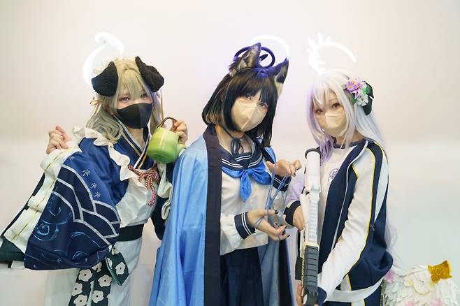 A trio of teenage cosplayers with Blue Archive costumes, who preferred to be known by their online aliases -- (from the left) Yujin, Hehe, and Nini -- dressed as the game’s characters Umika, Kikyou, and Azusa, respectively. (Moon Joon-hyun/The Korea Herald)