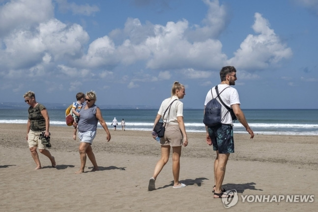 외국인 관광객이 발리섬 해변을 거닐고 있다./ EPA=연합뉴스