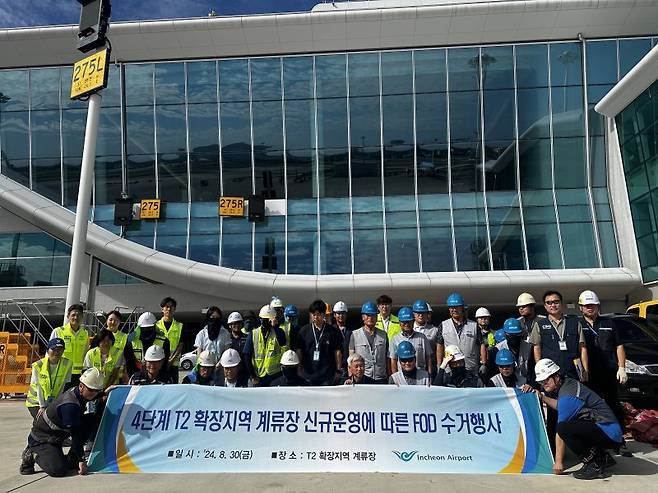 지난달 30일 인천공항 제2여객터미널 계류장 확장지역에서 진행된 '제2여객터미널 계류장 신규 확장지역 이물질(FOD) 수거행사'에서 참석자들이 기념촬영을 하고 있다. 인천국제공항공사 제공