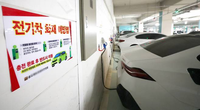 A fire hazard prevention notice is put up near an electric vehicle charging station at an underground parking lot of an apartment complex in Songdo, Incheon, on Aug. 12. (Yonhap)