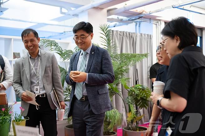 서울 성수동 연무장길에서 열린 ‘디지털 치유정원’ 팝업 전시에 참석한 한국수목원정원관리원 심상택 이사장(왼쪽 두 번째)이 전시를 관람하고 있다.(한국수목원정원관리원 제공) /뉴스1