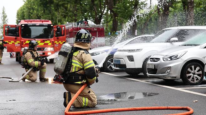 Firefighters practice extinguishing an electric vehicle fire during a drill at Maeheon Citizen's Forest parking lot in Seocho-gu, Seoul, on Sept. 2, 2024./News1