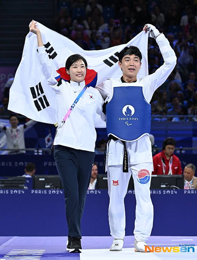 끝내 카자흐스탄 선수를 물리치고 동메달을 획득하며 김예선 감독(왼쪽)과 펼치는 ‘태극기’